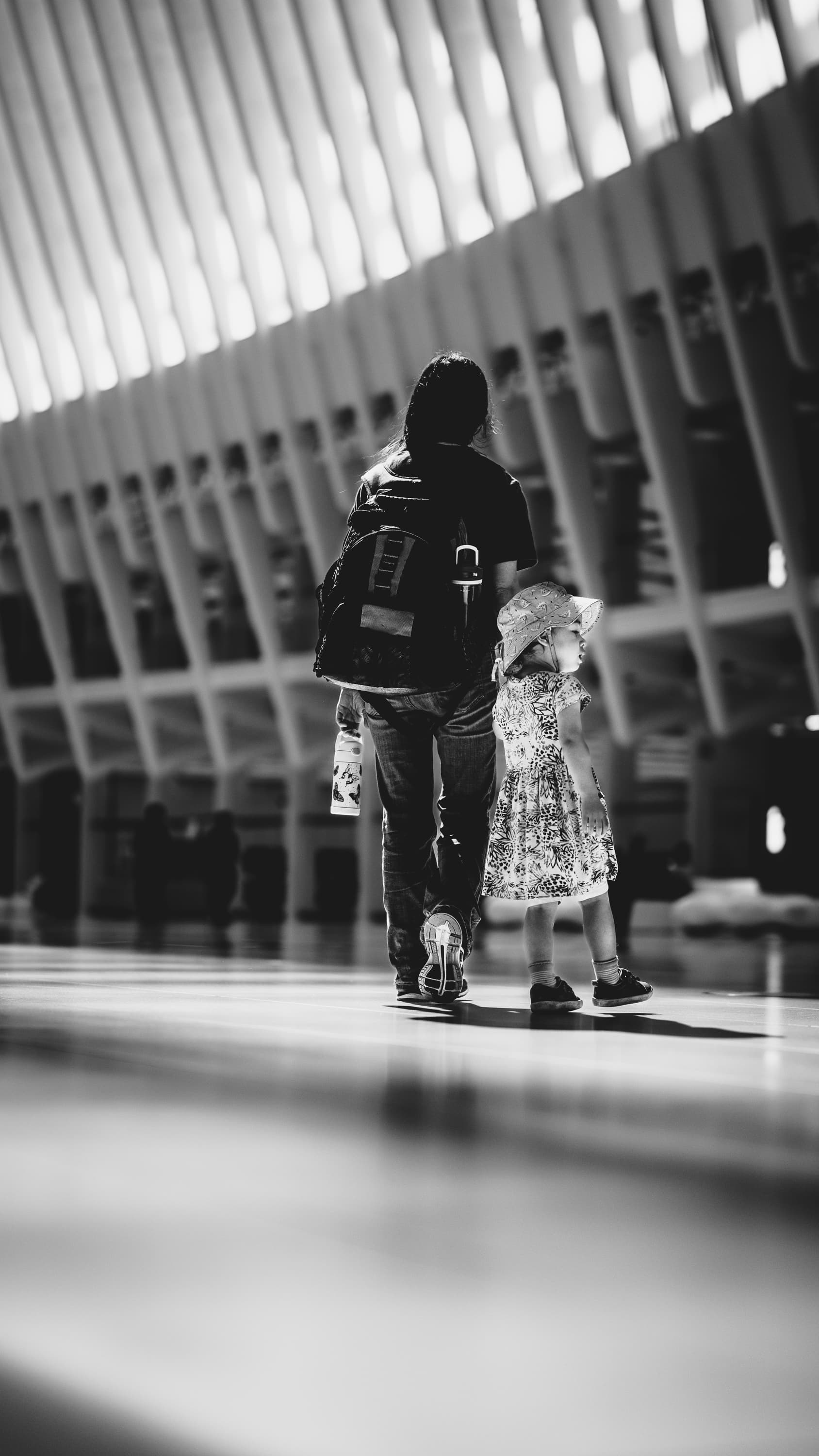 Mother and daughter walking through the Oculus at World Trade Center, New York — black and white architectural street photography