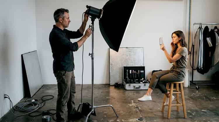 Fotógrafo preparando la iluminación para una sesión de retrato en estudio
