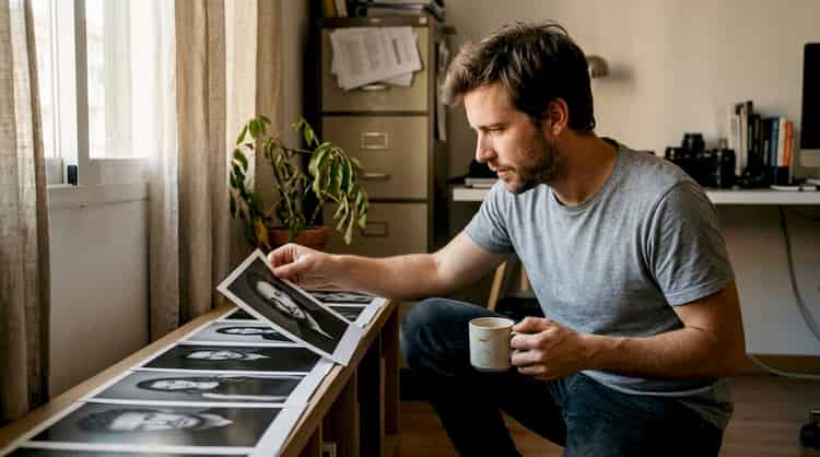 El fotógrafo revisa y elige los mejores retratos impresos en su estudio.