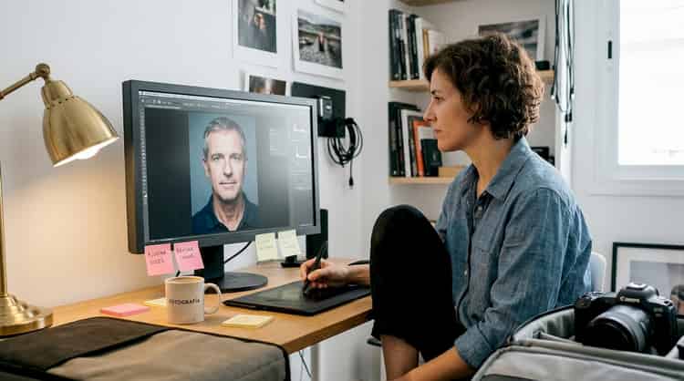 Professioneller Fotograf retuschiert ein Porträt in seinem Studio